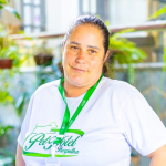 Aline, recreadora e banhista do Pet Hotel Pampulha, sorrindo durante o cuidado com os pets